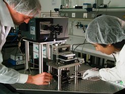 Thomas Utzig und Dr. Sangeetha Raman bei ihrem Versuchsaufbau zur Messung von Enthaftungsprozessen. Das Bild zeigt ein sogenanntes Rasterkraftmikroskop.
