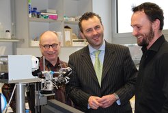 Dr. Karl Mayrhofer (rechts), dessen Projekt ECCO2 vom BMBF gefördert wird und Prof. Stratmann, Direktor am MPIE (links), erklären CDU-Bundestagsabgeordneten Jarzombek wie die am MPIE entwickelte Raster-Durchflusszelle für elektrochemische Analysen funktioniert.