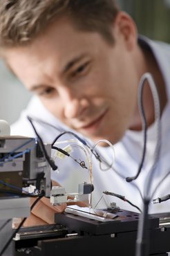 Dr. Sebastian Klemm mit seiner selbst entwickelten Raster-Durchflusszelle. Mit dieser elektrochemischen Analyse können Korrosionsschutz und eine Vielzahl anderer metallischer Legierungen auf Ihre Stabilität untersucht werden.