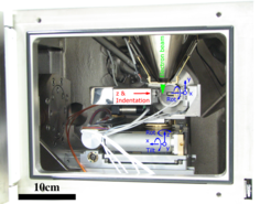 Fig. 1 Asmec Unat II installed in a Jeol JSM 6490 SEM, our standard testing rig for micron sized samples. The counterparty (e.g. a diamond or tungsten tip) is marked with “Indentation”, with the sample support pin opposite of it. Sample and indenter can independently be moved along 4 axis with submicron resolution. In addition, the entire setup can be oriented with 5 additional axis, which allows for versatile experimental setups (EBSD, ECCI)