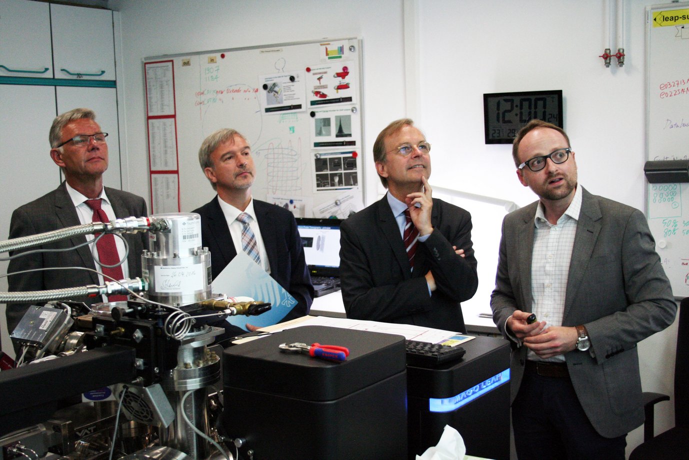 Thomas Rachel, Parlamentarischer Staatssekretär im Bundesministerium für Bildung und Forschung (Dritter von links), Prof. Dr.-Ing. Dierk Raabe, Direktor am Max-Planck-Institut für Eisenforschung und Leiter des Projektes (Zweiter von links) und Dr.-Ing. Peter Dahlmann, Geschäftsführendes Vorstandsmitglied des Stahlinstituts VDEh (Erster von links), mit Dr. Eric Jägle, Leiter der Gruppe „Additive Fertigung“, im Labor der Atomsonde, einem Mikroskop, mit dem die atomare Struktur von Stählen und anderen Materialien untersucht werden kann.