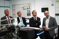 Thomas Rachel, Parlamentarischer Staatssekretär im Bundesministerium für Bildung und Forschung (Dritter von links), Prof. Dr.-Ing. Dierk Raabe, Direktor am Max-Planck-Institut für Eisenforschung und Leiter des Projektes (Zweiter von links) und Dr.-Ing. Peter Dahlmann, Geschäftsführendes Vorstandsmitglied des Stahlinstituts VDEh (Erster von links), mit Dr. Eric Jägle, Leiter der Gruppe „Additive Fertigung“, im Labor der Atomsonde, einem Mikroskop, mit dem die atomare Struktur von Stählen und anderen Materialien untersucht werden kann.