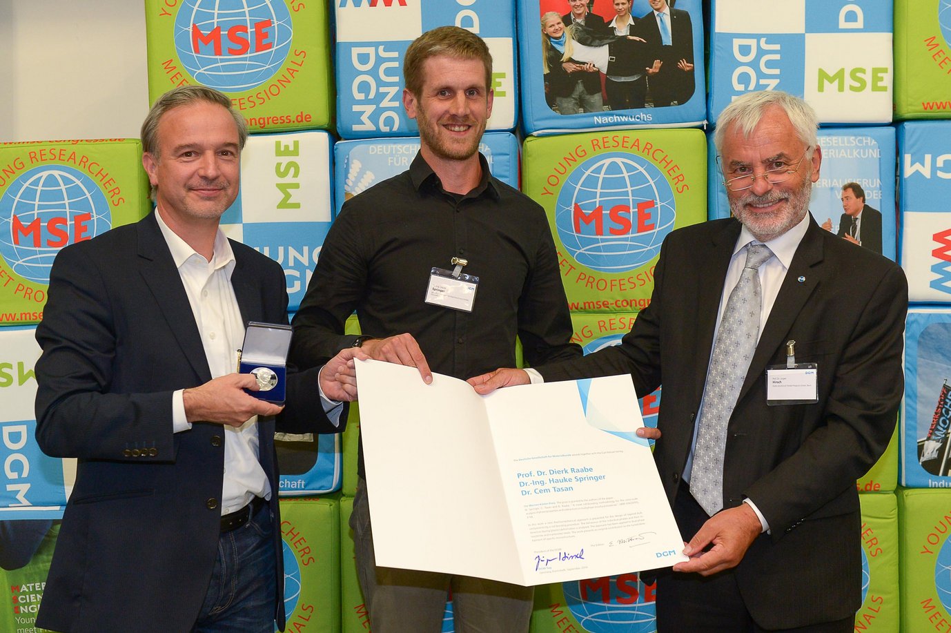 Prof. Dr.-Ing. Jürgen Hirsch (rechts), Vorstandsvorsitzender der Deutschen Gesellschaft für Materialkunde, übergibt Dr.-Ing. Hauke Springer (Mitte), Leiter der Gruppe „Kombinatorische Metallurgie und Prozesstechnik“, und Prof. Dr.-Ing. Dierk Raabe, Direktor der Abteilung „Mikrostrukturphysik und Legierungsdesign“ am Max-Planck-Institut für Eisenforschung, den Werner-Köster-Preis für ihre Publikation zu neuartigen Verfahren der Herstellung von mehrphasigen Strukturwerkstoffen.
