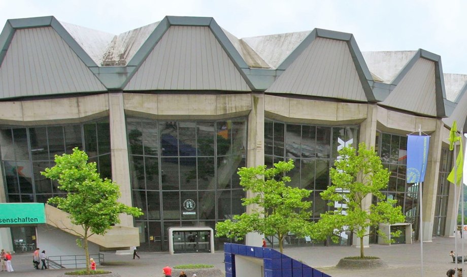 People walking and sitting in an urban plaza with modern buildings.