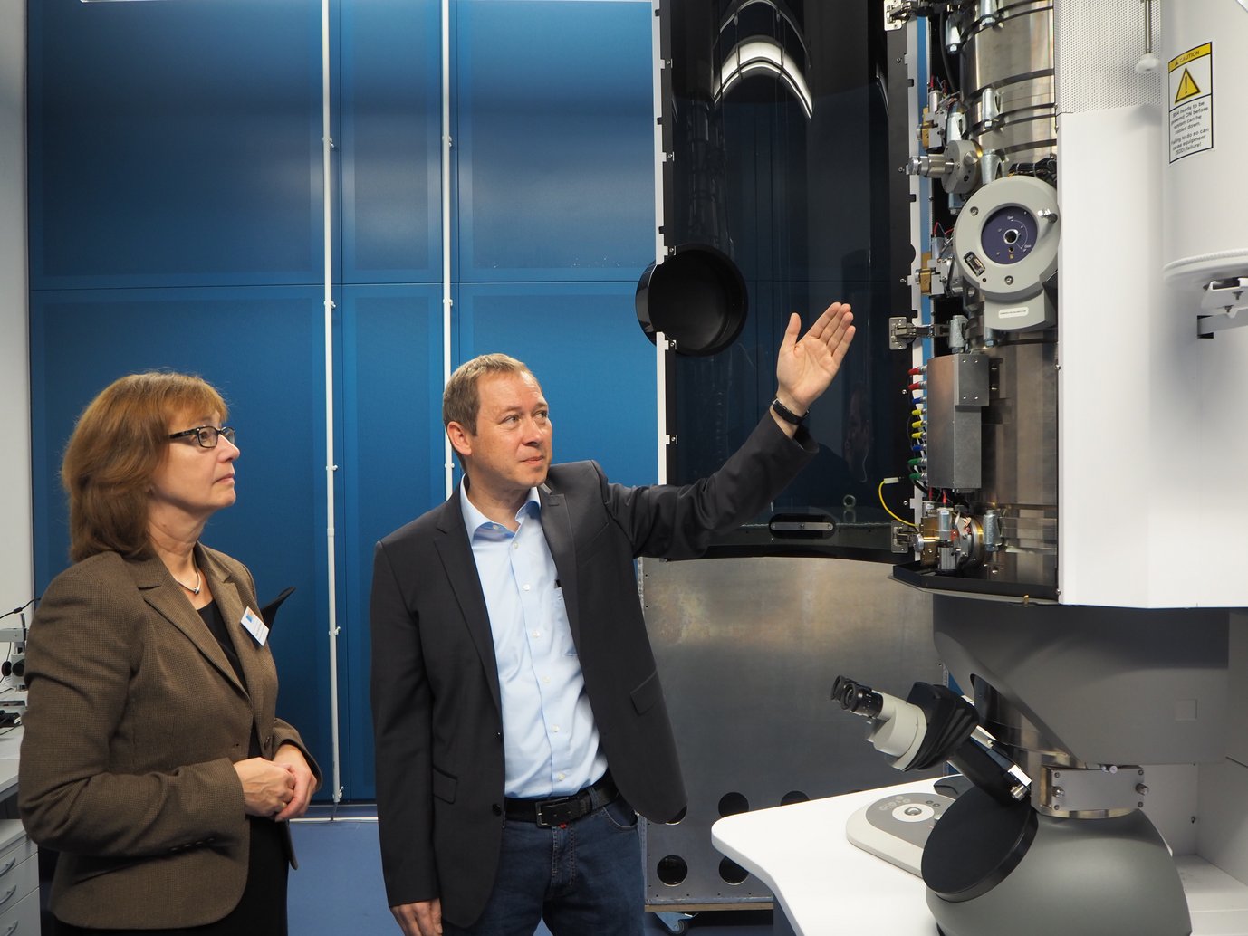 Prof. Gerhard Dehm, Direktor am Max-Planck-Institut für Eisenforschung, erklärt Susanne Schneider-Salomon vom Ministerium für Kultur und Wissenschaft, die Funktionsweise von Transmissionselektronenmikroskopen.