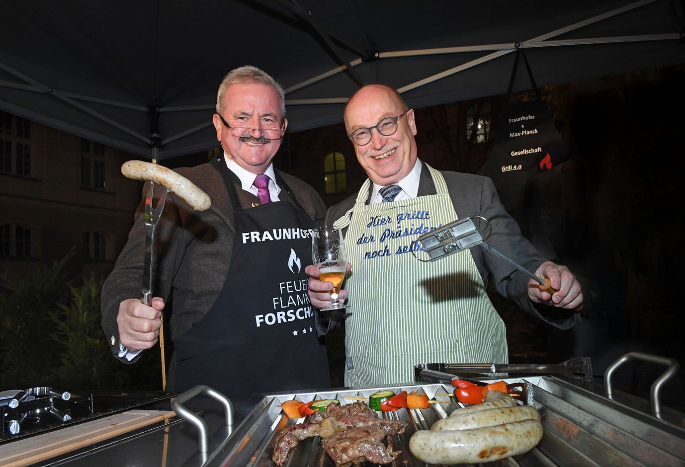 Von links: Der Präsident der Fraunhofer-Gesellschaft Prof. Reimund Neugebauer und der Präsident der Max-Planck-Gesellschaft Prof. Martin Stratmann testen den neuen High-Tech-Grill 4.0 das erste Mal aus.