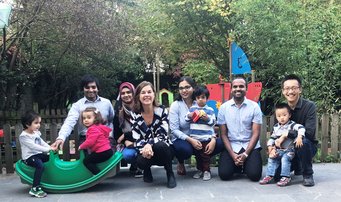 MPIE employees and their children together with Simone Degner (3rd from left), the equal opportunities officer, at the children's daycare. Group of adults and children in a garden setting.