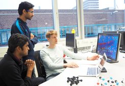 Dr. Michael Ashton (rechts) erklärt seinen Kollegen Sudarsan Surendralal (vorne links) und Ankit Gupta, Doktoranden der Abteilung Computergestütztes Materialdesign, seine Arbeit über das Verhalten von Werkstoffen in extremen elektrischen Feldern.