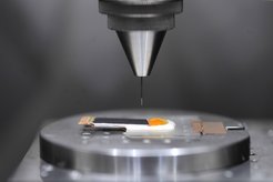 A look under the skin: Ashokanand Vimalanandan adjusts the Kelvin probe that enables him to monitor whether a given polymer coating gives corrosion protection and self-heals when damaged. A fine needle acts as the Kelvin probe's electrode, positioned above the sample. The dark layer is the self-healing skin. Underneath the drop is a defect in which corrosion is starting.