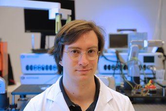 Scientific laboratory featuring sophisticated equipment including robotic arms and computers, indicative of advanced research activities.