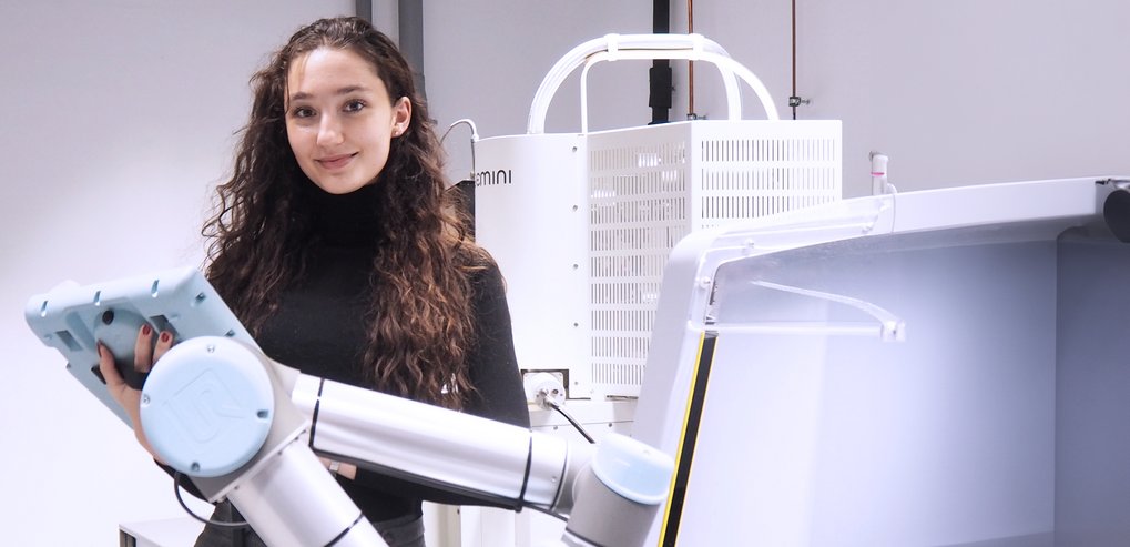 Eine Person bedient einen Roboterarm in einem Labor.