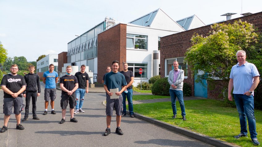 Simon Sprengel (Mitte) mit seinen Kollegen, Ausbilder Ralf Selbach (hinten rechts) und Geschäftsführer Kai de Weldige (zweiter von rechts) bei der Feier vor dem Werkstatttor am MPIE. Simon Sprengel (Mitte) mit seinen Kollegen, Ausbilder Ralf Selbach (hinten rechts) und Geschäftsführer Kai de Weldige (zweiter von rechts) bei der Feier vor dem Werkstatttor am MPIE.