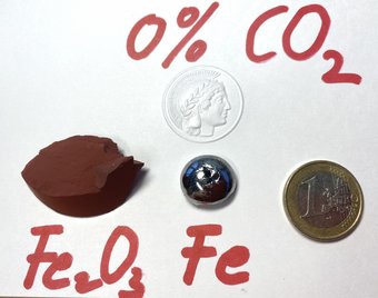 Iron oxide and metallic iron next to a euro coin.