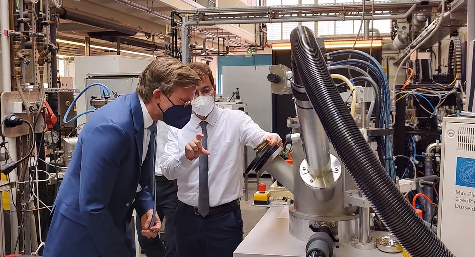 Dr. Isnaldi Souza (right), group leader at the Max-Planck-Institut für Eisenforschung, explains to State Secretary Dr. Dirk Günnewig how iron ores can be reduced to iron in an environmentally friendly way using hydrogen plasma.