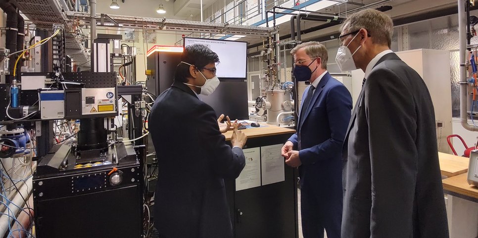Dr. Rajaprakash Ramachandramoorthy (left), group leader at MPIE, explains to State Secretary Dr. Dirk Günnewig (center) and Hartmut Pausewang, head of department at the Ministry of Culture and Science North-Rhine Westphalia, how he and his group are developing alloys for 3D printing of metals.