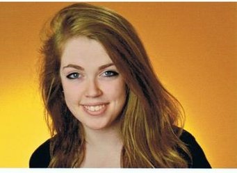 A subject with long, light brown hair, wearing a black garment, is positioned against a vibrant orange background, creating a striking contrast.