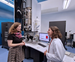 Julia Eisentraut (links), Mitglied des Landtags NRW und Sprecherin für Wissenschaft und Digitalisierung der Landtagsfraktion von BÜNDNIS 90/DIE GRÜNEN bei der Diskussion mit Raquel Aymerich Armengol, Doktorandin am Max-Planck-Institut für Eisenforschung. Zu sehen ist das Transmissionselektronenmikroskop welches Aymerich Armengol unter anderem für die Analyse von Katalysatoren zur Herstellung von grünem Wasserstoff verwendet.