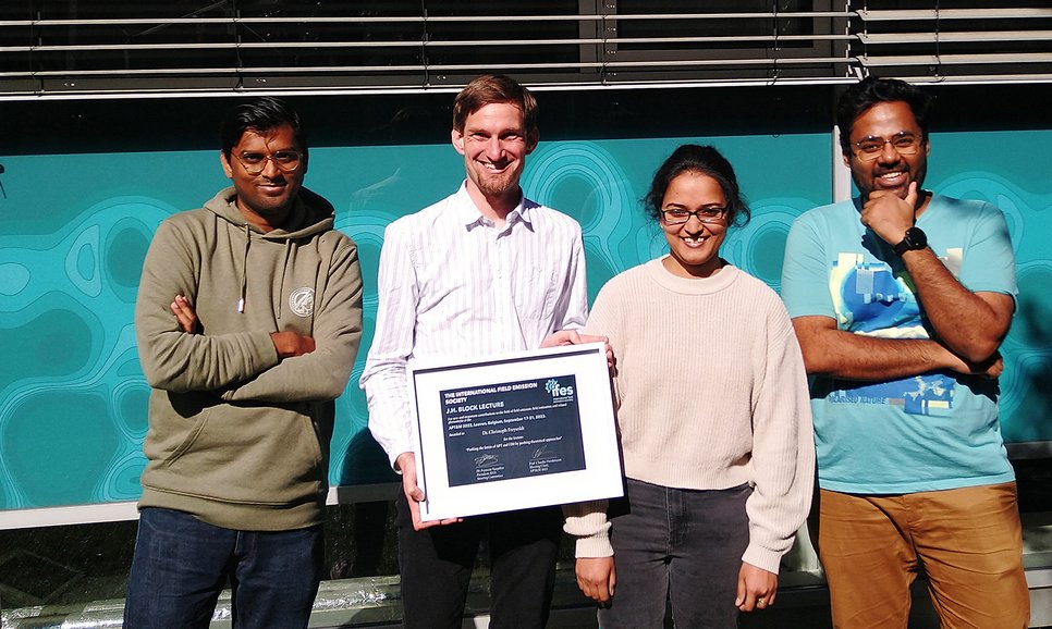 Dr. Christoph Freysoldt holding his certificate for giving the renowned J.H. Block Lecture, amongst his group members. The International Field Emission Society has chosen Freysoldt who heads the group “Defect Chemistry & Spectroscopy” at the Max-Planck-Institut für Eisenforschung, as the distinguished speaker for the J.H. Block Lecture at the Atom Probe Tomography and Microscopy Conference 2023 in Leuven, Belgium.