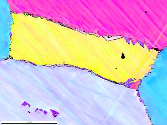 Hitzebeständig durch Nanopartikel: Winzige borhaltige Ausscheidungen an den Grenzen zwischen den im Mikroskopbild unterschiedlich eingefärbten Eisenaluminidstrukturen verhindern, dass die Legierung bei hohen Temperaturen weich wird. Mikroskopaufnahme, in der unterschiedliche Kristallphasen als Farbflächen dargestellt sind, die in Magenta, Gelb, Türkis und graumeliert eingefärbt sind.