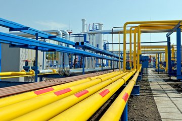 Bright yellow and blue pipelines in an industrial setting.