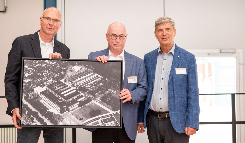 Von links nach rechts: Michael Rohwerder, Martin Stratmann und Jörg Neugebauer, Direktor am MPI-SusMat mit einem historischen Foto des Instituts.