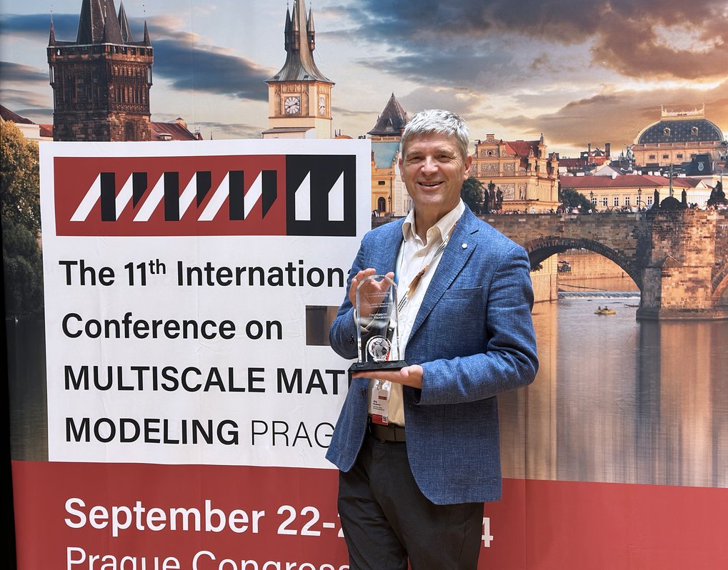 Person holding an award at a conference in Prague.