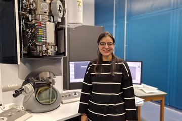 Woman at transmission electron microscope.