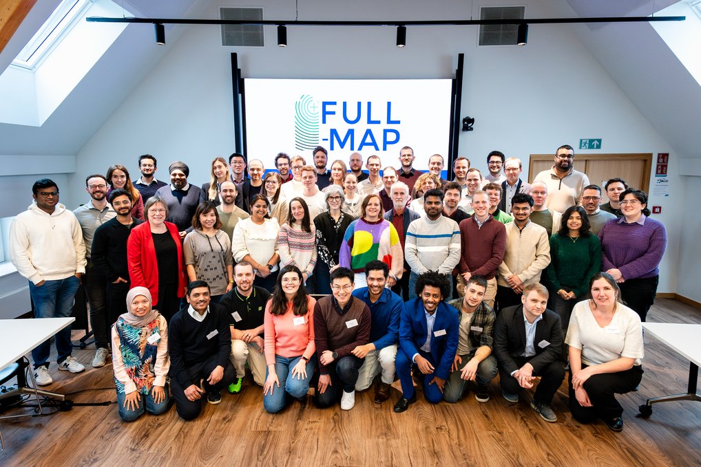 Im Forschungsprojekt Full-Map arbeiten Wissenschaftlerinnen und Wissenschaftler aus 12 europäischen Ländern zusammen, um eine digitale Materialplattform für bessere Batteriematerialien zu entwickeln. Gruppenfoto der an Full-Map beteiligten Wissenschaftlerinnen und Wissenschaftler vor einem Full-Map-Logo in einem hellen Raum.