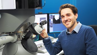 Dr. Peter Schweizer has established the Quantitative Transmission Electron Microscopy Group (QuanTEM) Together with his team, he focuses on analysing and quantifying atomic-scale structures, compositions, and properties of materials using high-resolution imaging and advanced microscopy techniques. Man at electron microscope.
