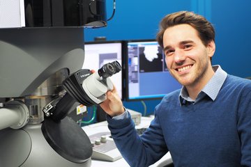 Man at electron microscope.