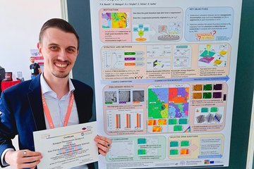 Person standing next to scientific poster about thermoelectrics.