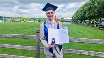 Florian Busch receives Springorum Commemorative Coin by RWTH Aachen University for his master thesis on thermoelectric materials. Man in suit holds certificate and commemorative coin.