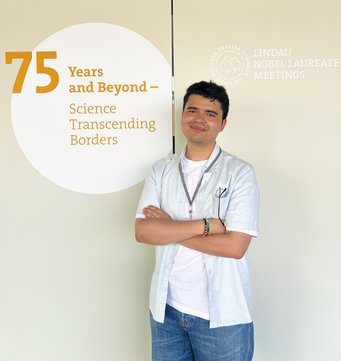 Alvaro Diego Bedoya Zapata, PhD researcher at the Max Planck Institute for Sustainable Materials, has been selected to participate at the 75th Lindau Nobel Laureate Meeting, taking place from 28 June to 3 July 2026. Man standing in front of a beige wall with a text about the 75 anniversary of the Lindau Nobel Laureate Meeting.