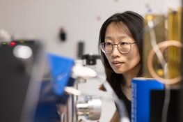 Woman scientist wearing glasses working with scientific equipment in a laboratory.