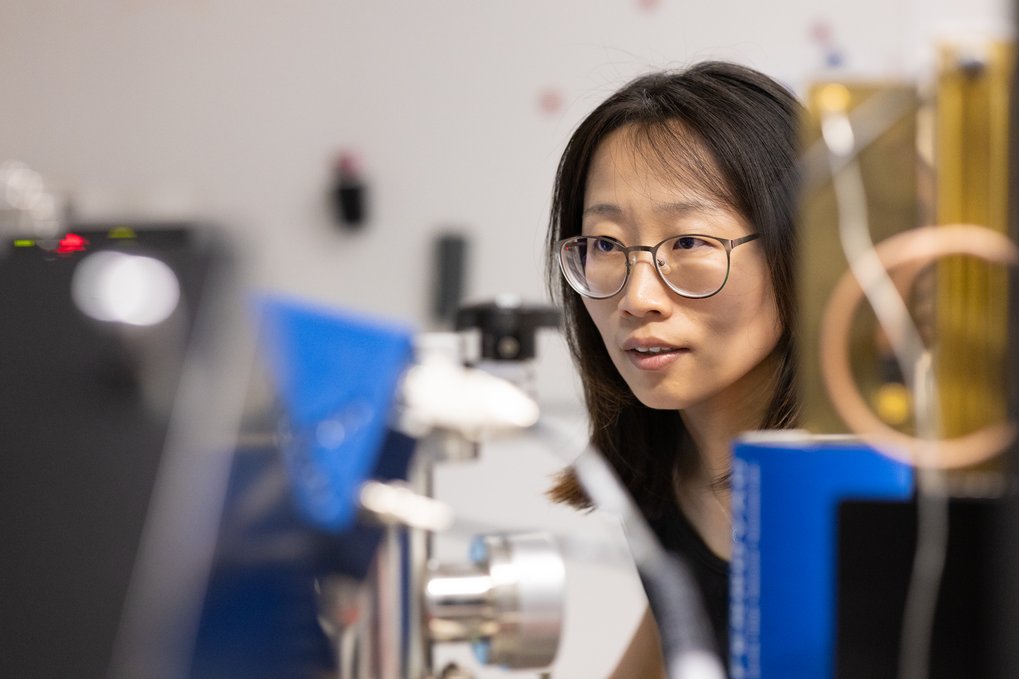 Wissenschaftlerin mit Brille arbeitet in einem Labor mit technischen Geräten.