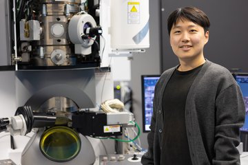 Man standing next to scientific device.