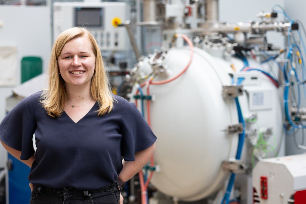 Woman standing in front of industrial device.