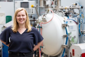 Woman standing in front of industrial device.