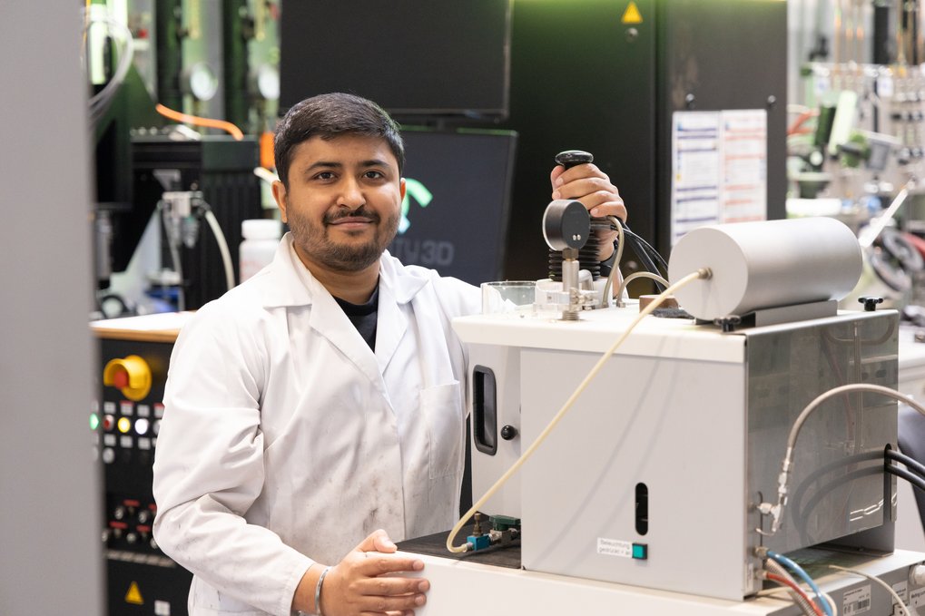 Man in lab coat operating a scientific device.