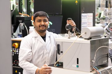 Man in lab coat operating a scientific device.