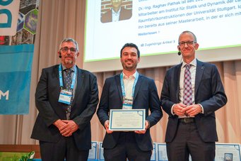 Dr Tim M. Schwarz (centre) received the DGM Young Scientist Award 2026 for his research into solid–liquid interfaces and liquids at the atomic scale, with applications in biological, battery and catalytic materials. The award certificate was presented by Prof. Gunther Eggeler (left) and Prof. Till Schneiders, both presidents of the German Materials Society (DGM). Three men in suits are standing on a stage. The man in the middle is holding a certificate.
